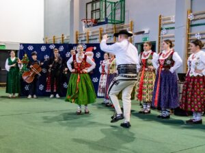 Góral i góralką tańczą. W tle kapela góralska.