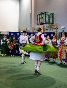 Góral i góralką tańczą. W tle kapela góralska i góralki.