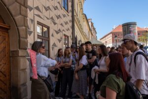 Pani przewodnik objaśnia młodzieży miarę średniowiecznego praskiego łokcia.