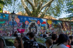 Widok na mur pokryty graffiti i napisami czyli tzw. Lennon Wall.
