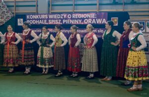 Uczennice w strojach regionalnych śpiewają piosenkę w gwarze regionalnej druga część szeregu