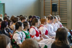 Publiczność w strojach regionalnych z zaciekawieniem obserwuje prezentacje uczestników konkursu.