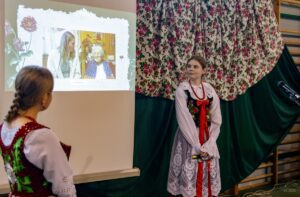 Zbliżenie na dziewczynę prezentującą informacje o twórcy regionalnym Pani Krystynie Aleksander z Krościenka nad Dunajcem.