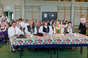 Szacowne jury dwóch panów i trzy panie siedzące za stołem wszyscy w strojach regionalnych.