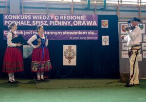 Dwie uczennice obserwują grającego na skrzypcach swojego kolegę z drużyny konkursowej.