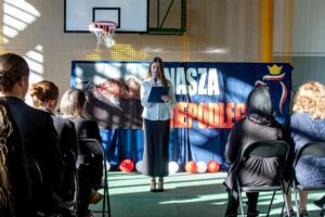 9. Na scenie ładna konferansjerka zapowiada następną wykonawczynię.