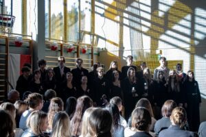 13. Zbliżenie na uczniów i uczennice tworzące chór.