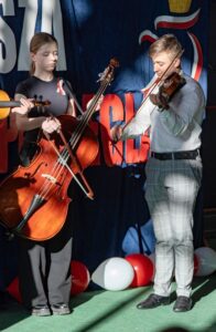 19.Zbliżenie na grających basistkę i skrzypka.