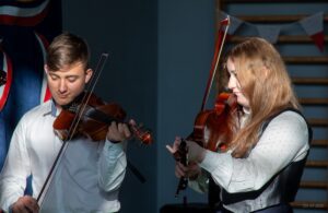 20. Drugie zbliżenie na dwoje uczniów grających na skrzypcach.