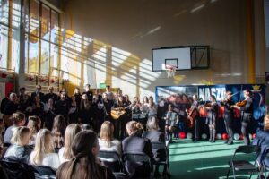 24. Całą scenę zajmuje występujący chór i zespół muzyków.