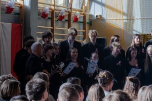 25. Zbliżenie na śpiewających uczniów w chórze.