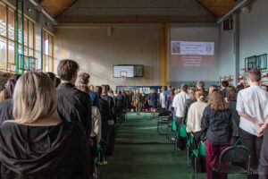 31. Całość zgromadzonych stoi w postawie zasadniczej, gotowa do odśpiewania hymnu narodowego.