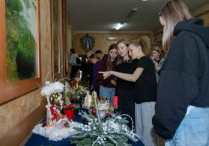 Z grupy uczniów jedna z uczennic wskazuje na jeden ze stroików.