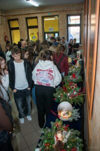 Uczniowie przy stołach starają się wybrać ten najładniejszy.