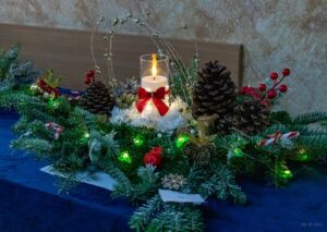 Zbliżenie na stroik z zaświeconą świecą.