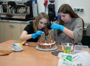 Dwie uczennicy ozdabiają pierniki.