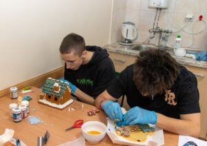 Dwóch uczniów wykonuje piernikowe ozdoby.