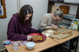 Dwie uczennice żmudnie zdobią pierniki.