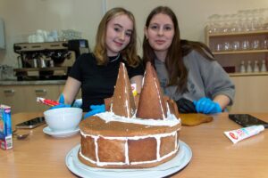 Na pierwszym planie powstająca piernikowa budowla a w tle jej wykonawczynie.