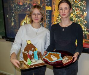 Jeszcze jedno zdjęcie uczennic, które na tle wyświetlonej prezentacji świątecznej prezentują swoje dzieła.