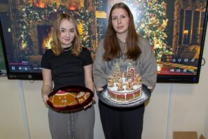 Jeszcze jedno zdjęcie uczennic, które na tle wyświetlonej prezentacji świątecznej prezentują swoje dzieła.