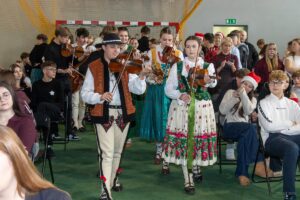 Na scenę maszeruje kapela w strojach regionalnych grając przepiękną melodię kolędy.