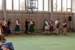 Na scenę wchodzi kapela góralska grając melodię kolędy.