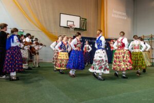Dziewczęta z zespołu góralskiego zaczynają w kółeczku tańczyć taniec góralski.