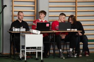 Na fotografii obsługa techniczna koncertu, czterech uczniów za konsoletą i laptopem.