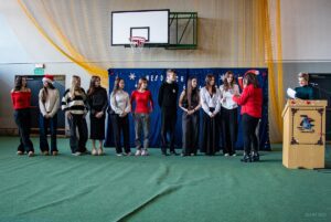 Dwie nauczycielki wręczają dyplomy nagrodzonym uczniom w konkursie zdobienia pierników.