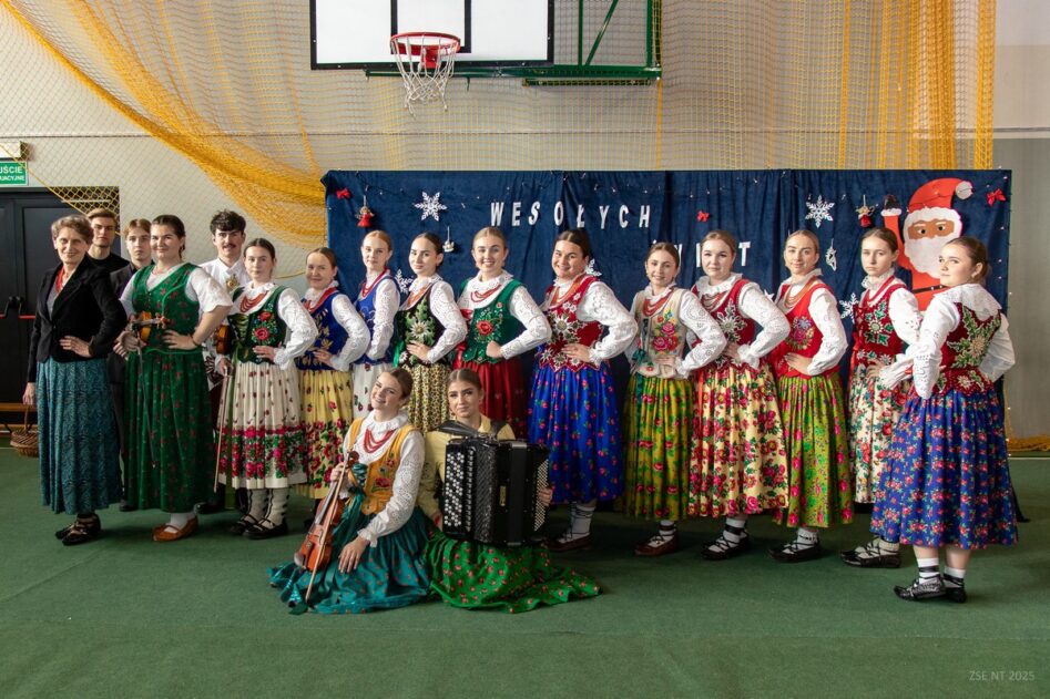 Uśmiechnięci członkowie kapeli i dziewczęta z zespołu góralskiego wraz z opiekunką.