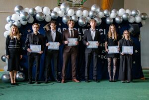 Druga grupa nagrodzonych absolwentów - sportowców wraz z opiekunką nauczycielką przedmioty wychowanie fizyczne.