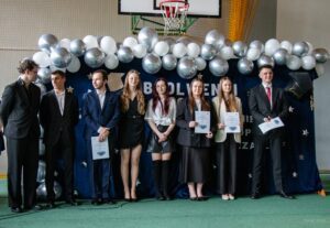 Grupa ośmiorga absolwentów nagrodzona za reprezentowanie szkoły w zawodach sportowych.