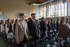 Stojący w postawie zasadniczej śpiewają hymn narodowy.