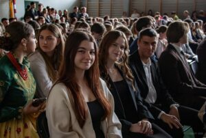 Zbliżenie na siedzących kilkoro uczniów - absolwentów szkoły.