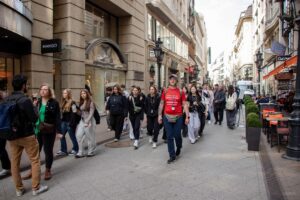 Ulicą na czele z przewodnikiem idzie grupa uczniów.
