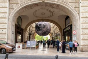 Widok na jedną z turystycznych atrakcji, wiszący model Ziemi widziany przez bramę.