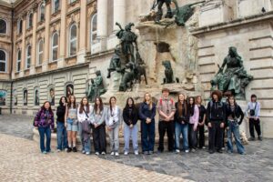 Uczniowie klasy 2 TH wraz z wychowawczynią na tle historycznej fontanny.