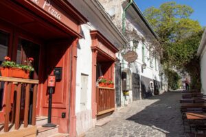 Wąska uliczka w Szentedre z małą pizzerią na pierwszym planie.