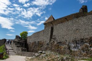 Widok na wysokie kamienne mury zamku wysokiego.