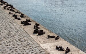 Widok na mosiężne odlewy butów ludzkich na nabrzeżu Dunaju, które są pomnikiem pomordowanych budapesztańskich Żydów.