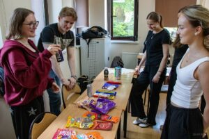 Uczennice patrząc na prezentowane przez studentkę napój energetyczny wysłuchują pogadanki o niebezpieczeństwie ich spożywania.