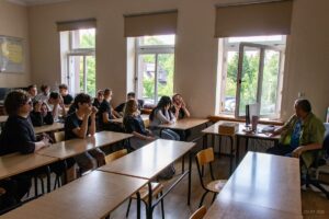 Strefa zdrowia psychicznego uczniowie w ławkach czekają na pogawędką pana psychologa.